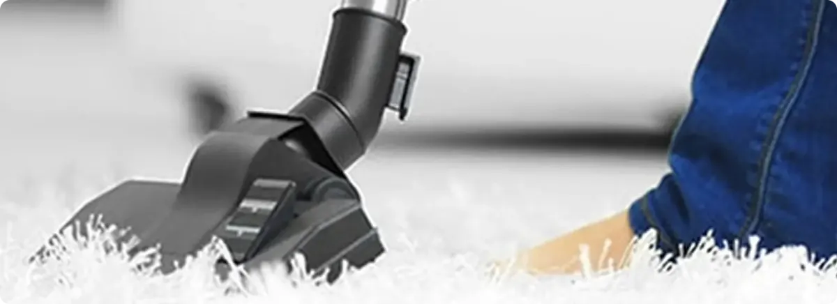 Close-up of a professional vacuuming a white carpet in Peoria.